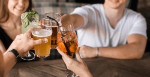 Pessoas reunidas brindando com seus copos de vidro.