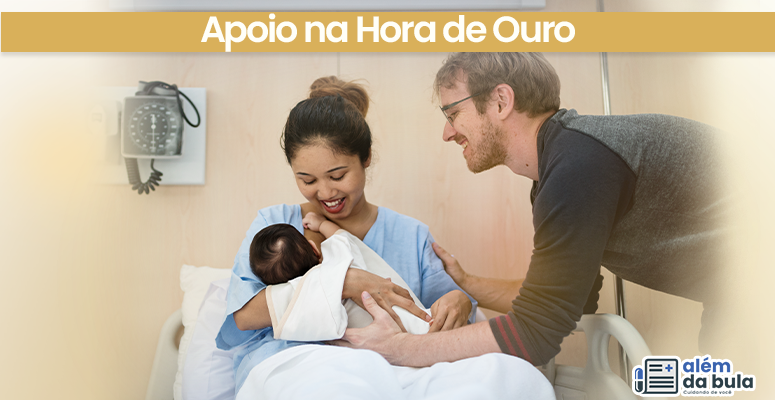 Mãe segura bebê no colo em hospital, enquanto acompanhante sorri ao lado. Cena mostra apoio familiar na primeira hora de vida.
