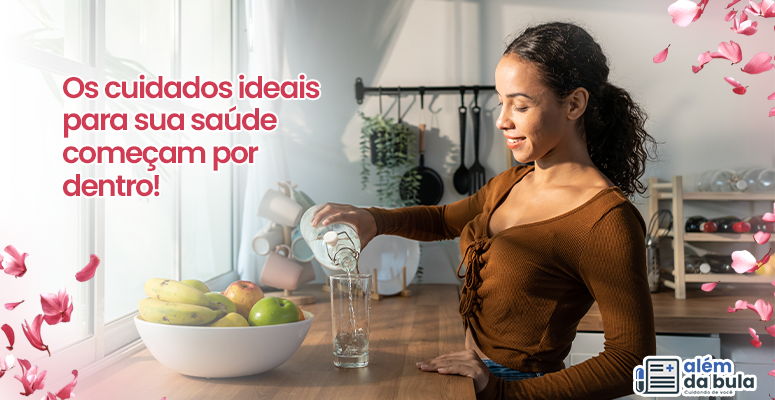 Na imagem tem uma mulher negra colocando água em um copo enquanto sorri, ela está usando uma blusa marrom e está em um ambiente de cozinha. Na imagem tem flores ilustrativas e a seguinte frase na imagem: 'Os cuidados ideais para sua saúde começam por dentro'.